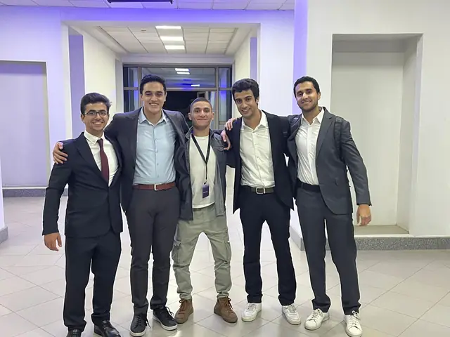 Five friends, four in suits and one in a jacket with a name tag.