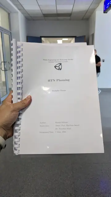 A hand holding the spiral-bound thesis titled HTN Planning.